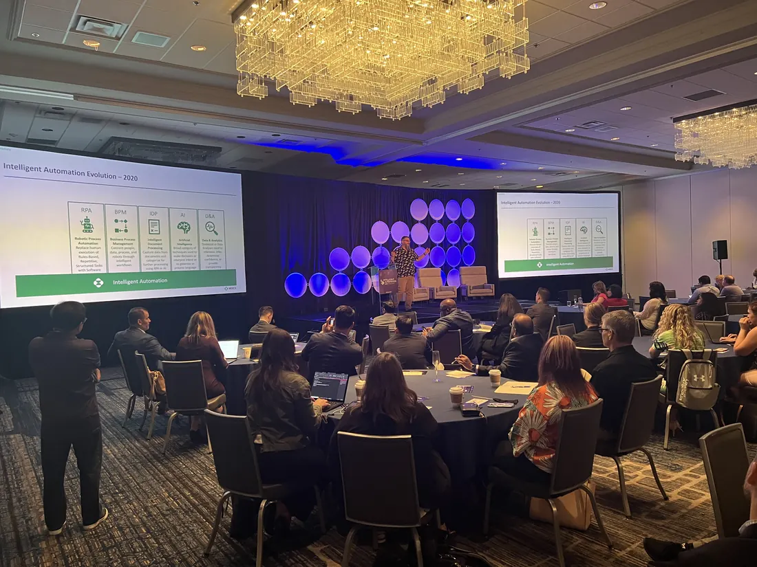 Conference ballroom in Chicago with two screens and a lit stage backdrop